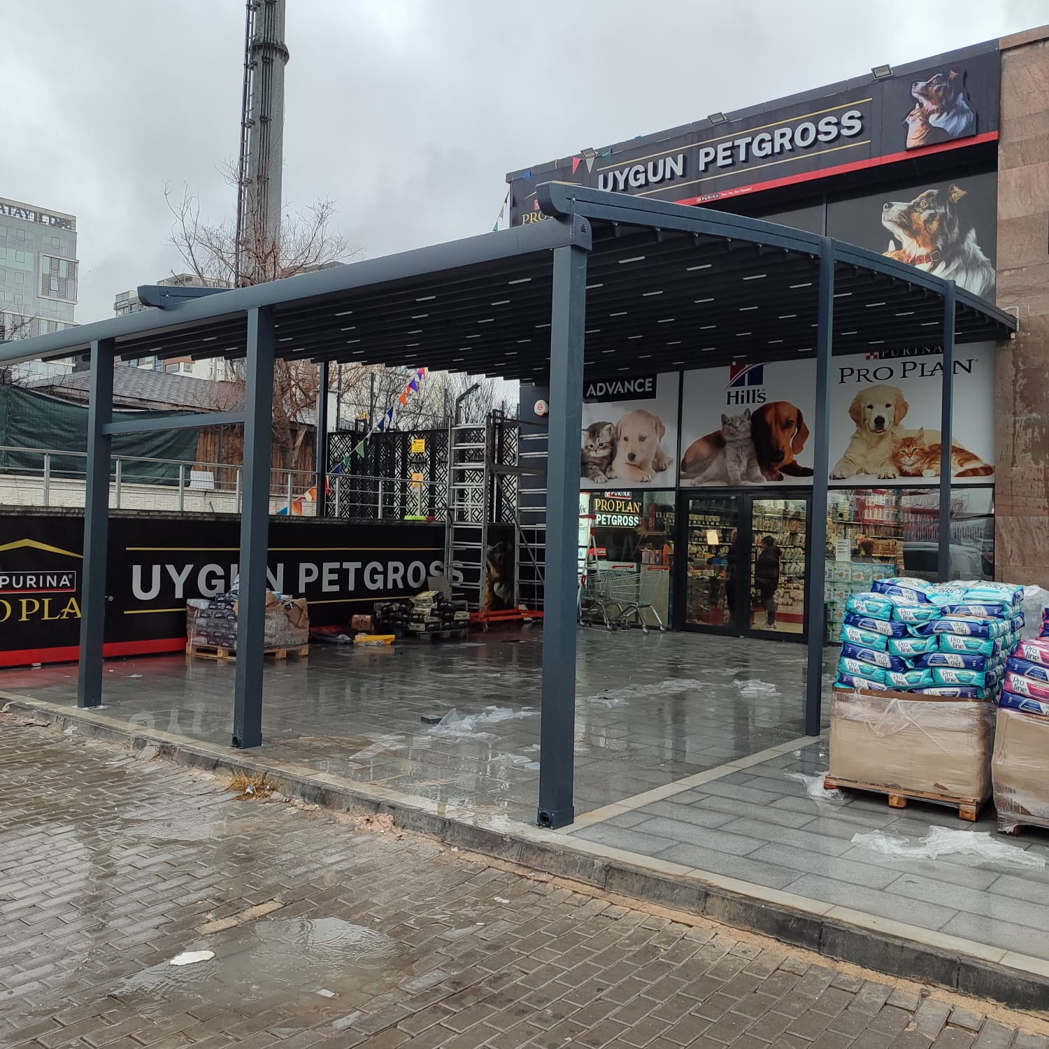 Bahçe terasında alüminyum pergola; üstte açılır kumaş, altta oturma alanı 3