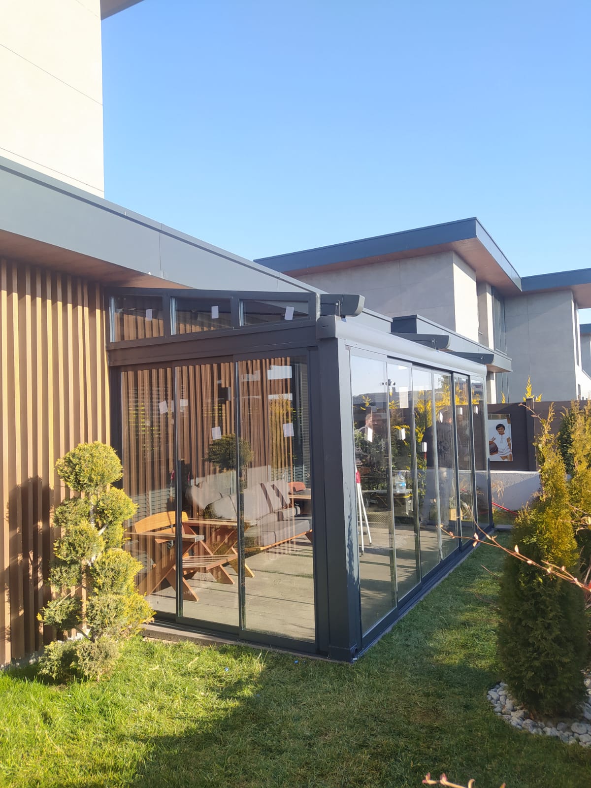 Bahçe terasında alüminyum pergola; üstte açılır kumaş, altta oturma alanı 14
