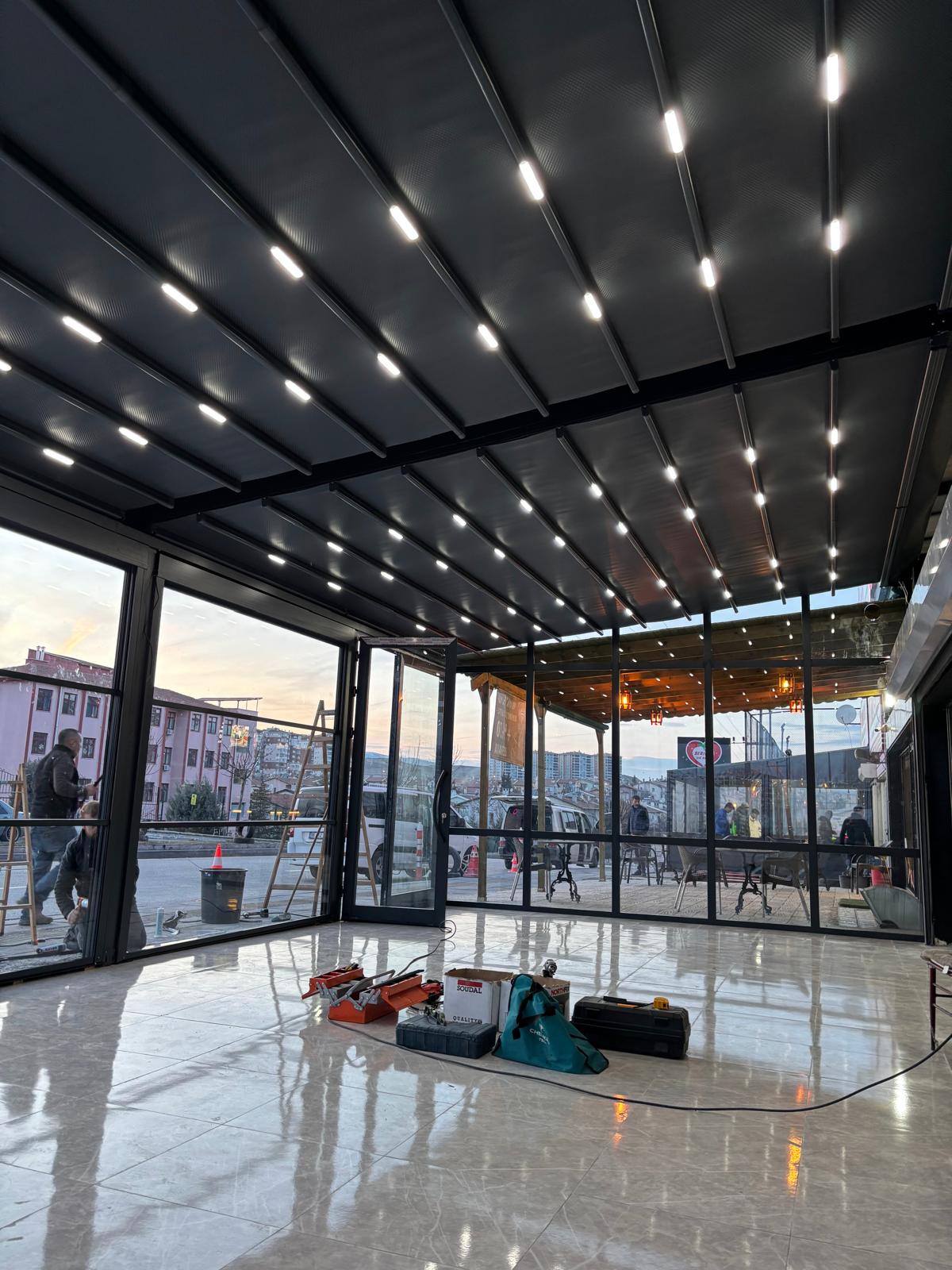 Bahçe terasında alüminyum pergola; üstte açılır kumaş, altta oturma alanı 17