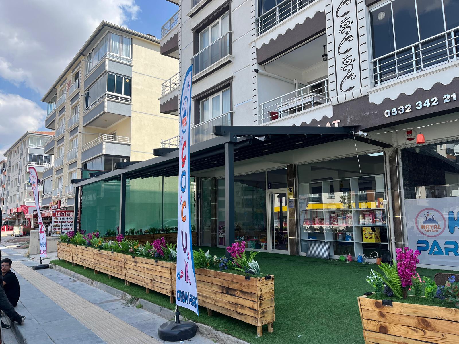 Bahçe terasında alüminyum pergola; üstte açılır kumaş, altta oturma alanı 18