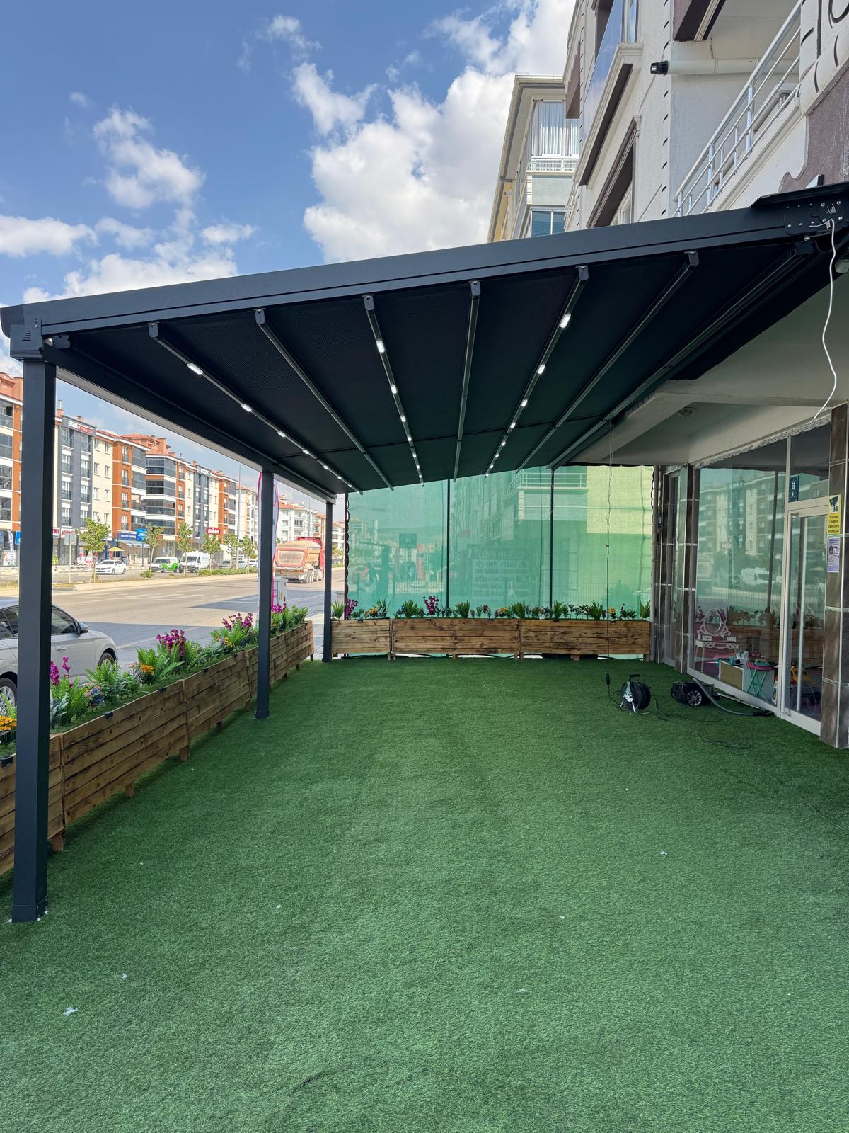 Bahçe terasında alüminyum pergola; üstte açılır kumaş, altta oturma alanı 22